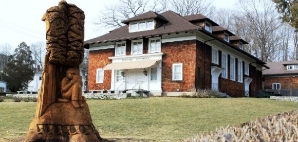 Front view of  the Ivoryton Playhouse with its new wood sculpture carved from the trunk of the tree, which fell during Storm Sandy in the foreground.