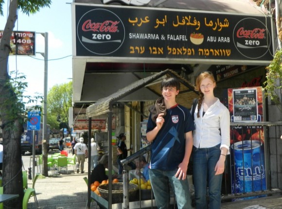 Abigail Cipparone stands with her brother in front of a tore in Israel-Palestine during their visit there last year.