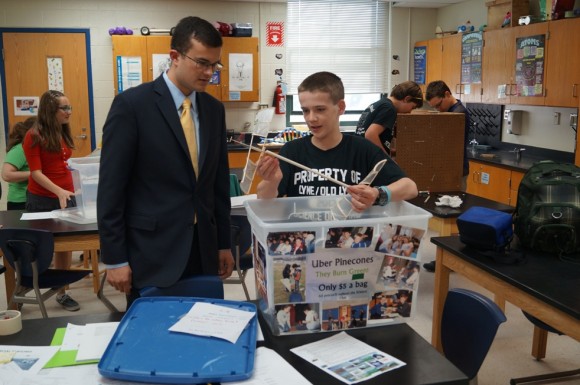 Sen. Art Linares (left) listens while Lyme-Old Lyme Middle School student Ethan Harris describes his elastic-propelled helicopter.