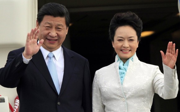 In this file photo, Xi Jinping and his wife Peng Liyuan wave to the crowd.