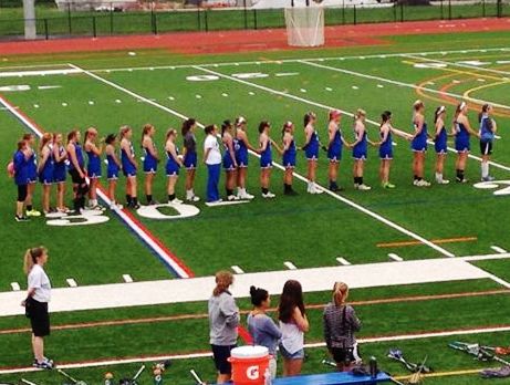 Photo by L. Buckley.  With hands joined in unity, the Old Lyme girls stand to attention during the national Anthem.