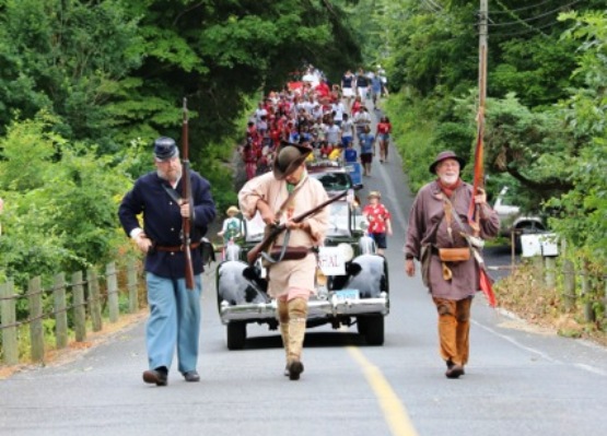 Photo by P. Daitch.  View looking up Cove Road of the musketeers leading the parade.