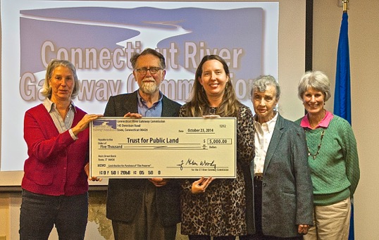 Connecticut River Gateway Commission Chairman Melvin Woody presents a $5,000 contribution to The Preserve Fund to Kate Brown (center), Trust for Public Land Project Manager for “The Preserve” acquisition. On the far left is Commission Vice Chair Nancy Fischbach, and on the right are Commission Secretary Madge Fish & Treasurer Margaret (“Peggy”) Wilson.