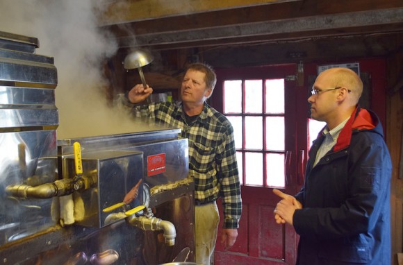 Don Bureau demonstrates part of the maple syrup-making process to Rep. Devin Carney.