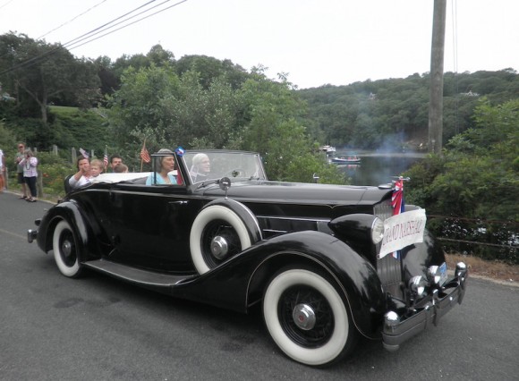 Janis Witkins, Grand Marshal of Lyme's 2015 Independence Day Parade, is driven by George Willauer in his splendid antique automobile. 