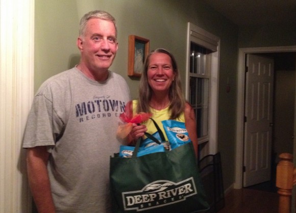 Beth Sullivan stands holding her prize of Deep River Snacks with her husband Michael.