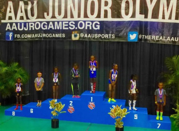 Zoe Eastman-Grossel stands on the medal- winners podium after placing sixth in the Junior Olympics long jump.