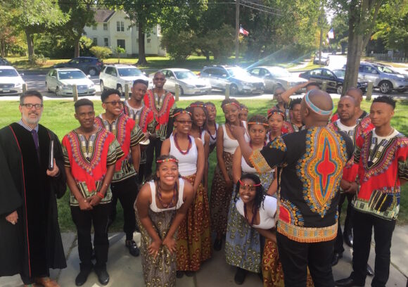 The Pretoria Indigenous Choir stands on the steps of the First Congregational Church of Old Lyme. Senior Minister Steve Jungkeit at left and chorus Director Mxolsi Duda at back row third from left.