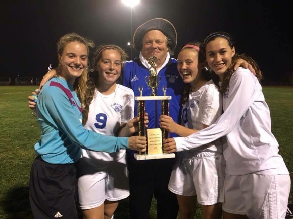 Paul Gleason, veteran coach of the girl's soccer team, shares a smile with several of his players after winning the Shoreline Championship last night.