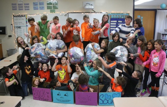The students of Ms. Alger's class at Lyme Consolidated School show their pride in the socks they collected.