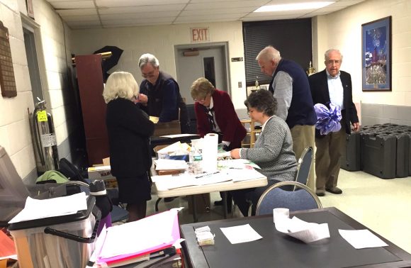 Poll workers tally totals at the Cross Lane FireHouse after voting closed in Tuesday's presidential primary election.