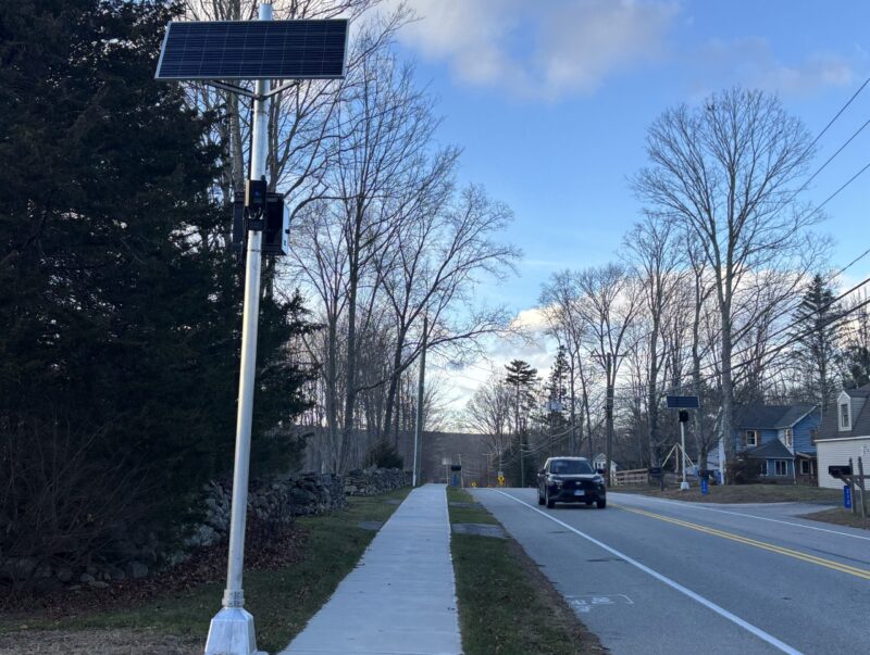Automated traffic enforcement cameras are seen on either side of the road as a car drives by in Marlborough, CT.